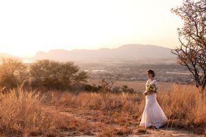 Bride walking through landscape during sunset wedding portraits in Gauteng