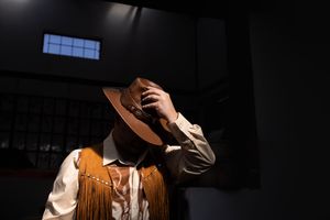 Groom getting ready with hat during wedding preparation in Gauteng with dramatic lighting