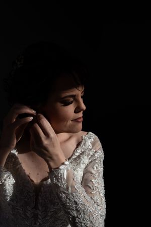 Bride putting on earrings during wedding preparation in Gauteng with soft, natural lighting
