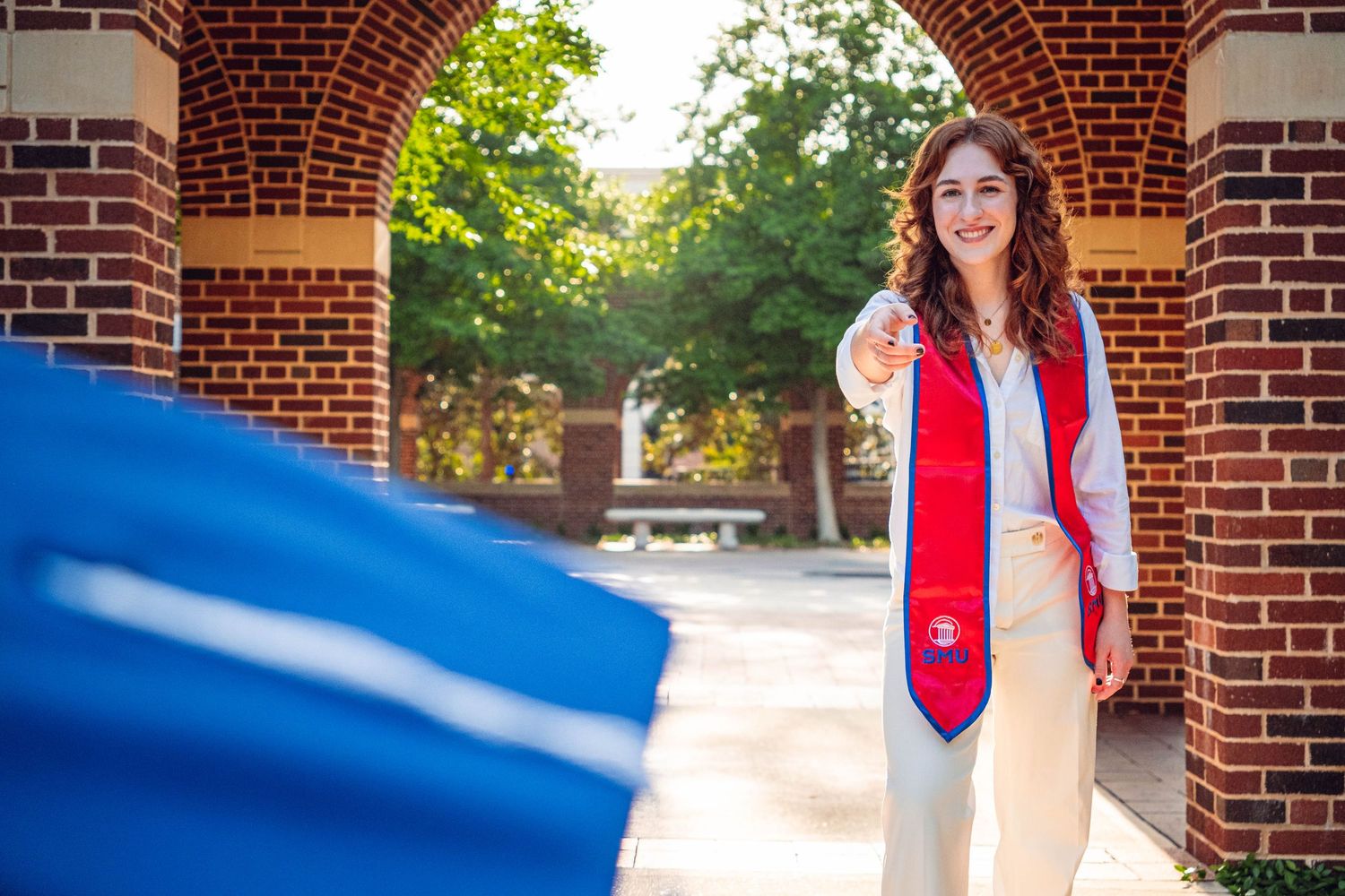 Red brick archway frames an outdoor portrait session on a college campus.