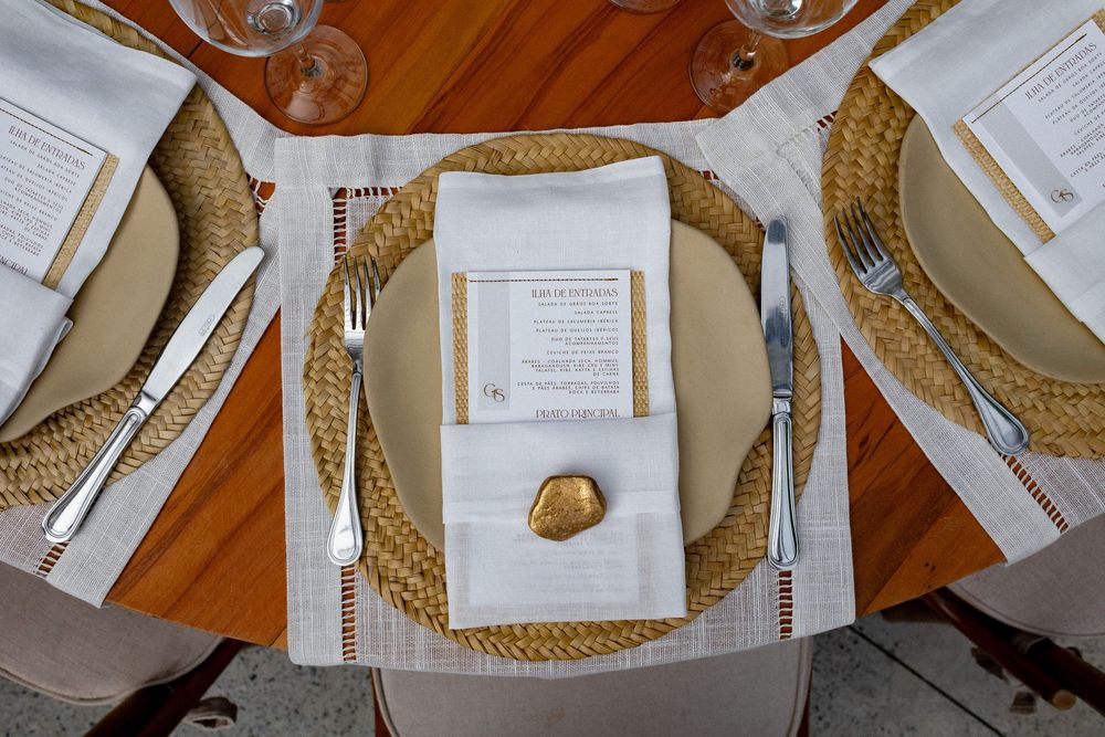 A collage of traditional place settings with gold-rimmed plates and white napkins arranged on a wooden table.