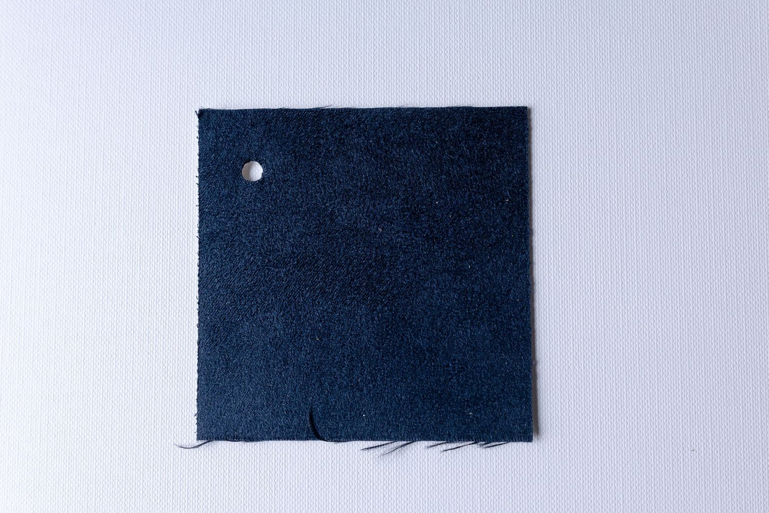 A series of five dark blue rectangular fabric swatches arranged in a horizontal row against a light background.