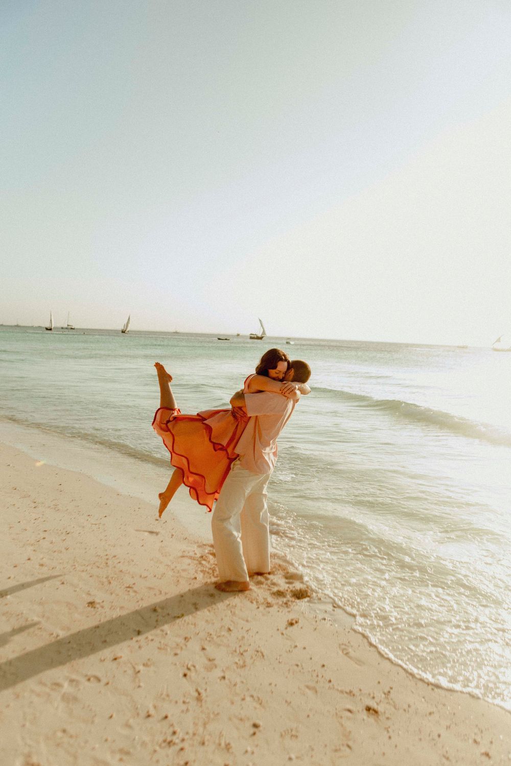 Cinematic couple walking along Jambiani Beach