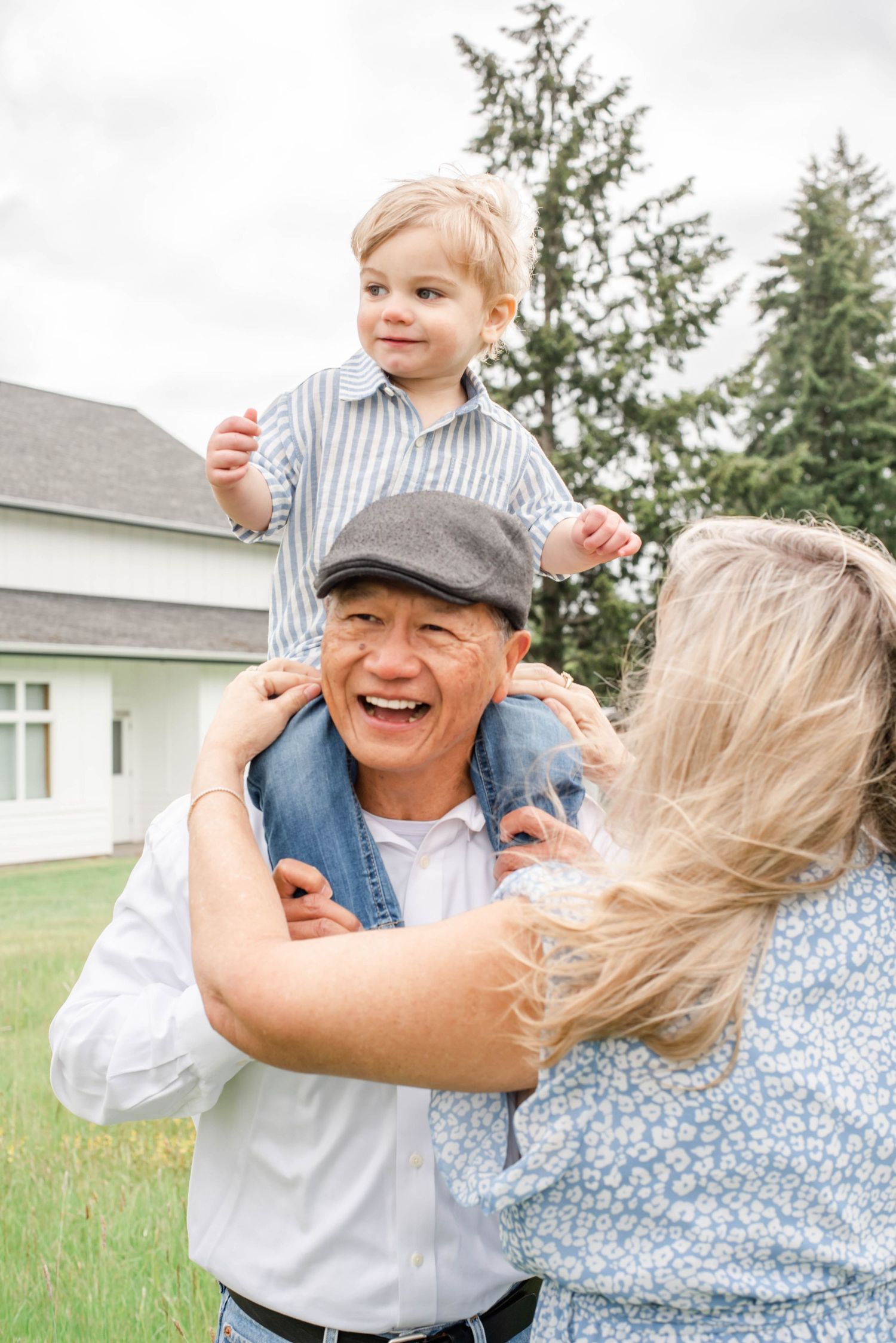 A joyful family moment outdoors with evergreen trees in the background on a sunny day.