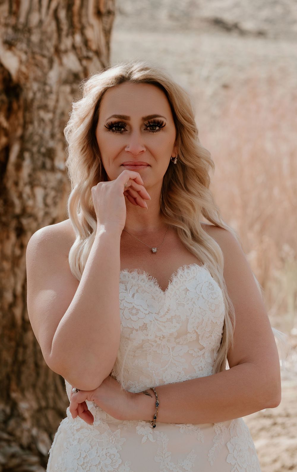 A person in a white lace wedding dress poses outdoors in a series of emotional candid moments.