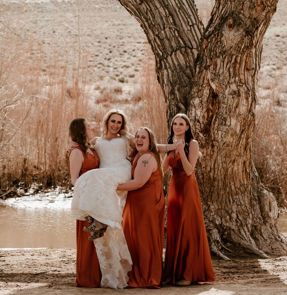 Bridesmaids in rust-colored dresses pose playfully in a series of candid shots by a large tree trunk.