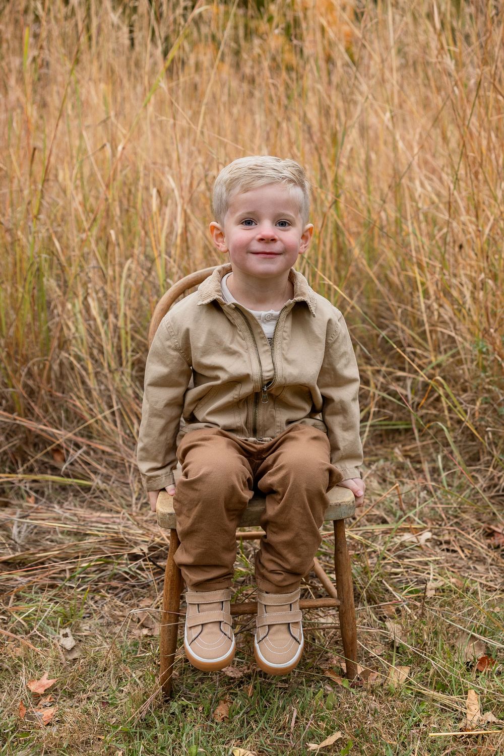 A series of three photos showing a child in brown clothing sitting on a wooden chair in tall autumn grass.