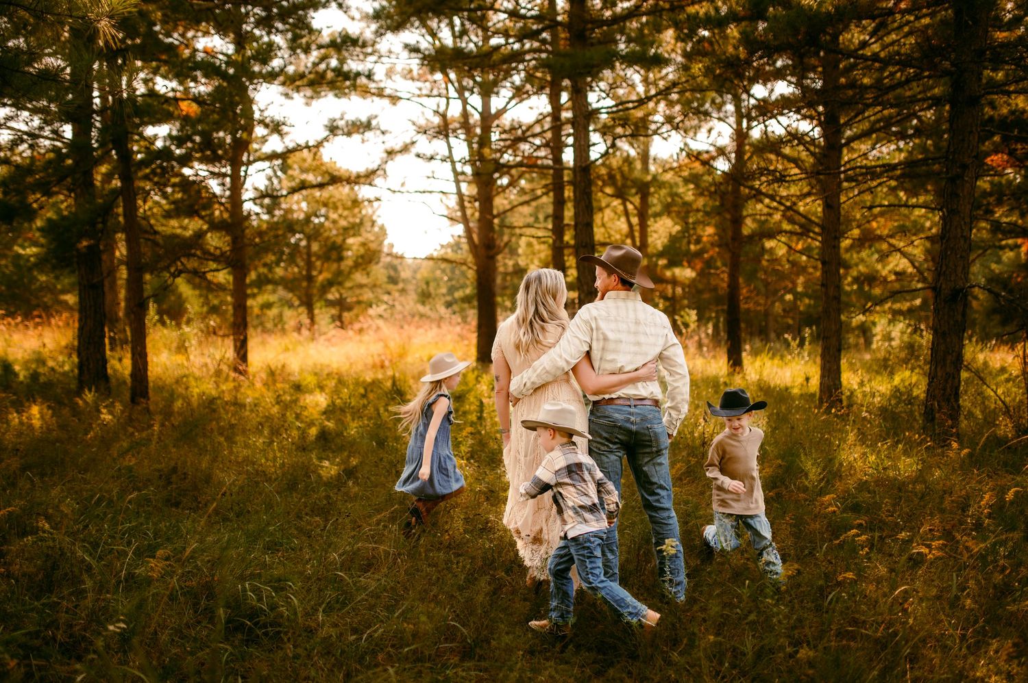 A couple shares tender moments in a golden-lit forest during sunset, creating romantic autumn portraits.