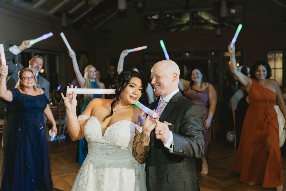 Wedding guests dance together during a joyful reception celebration on the dance floor.