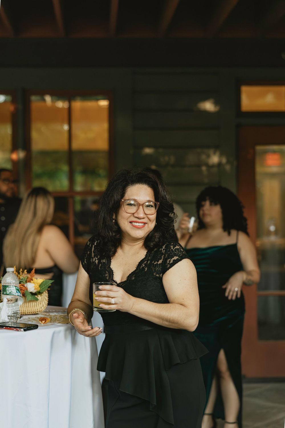 Guest enjoying drinks and refreshments at an elegant evening event in a black dress.