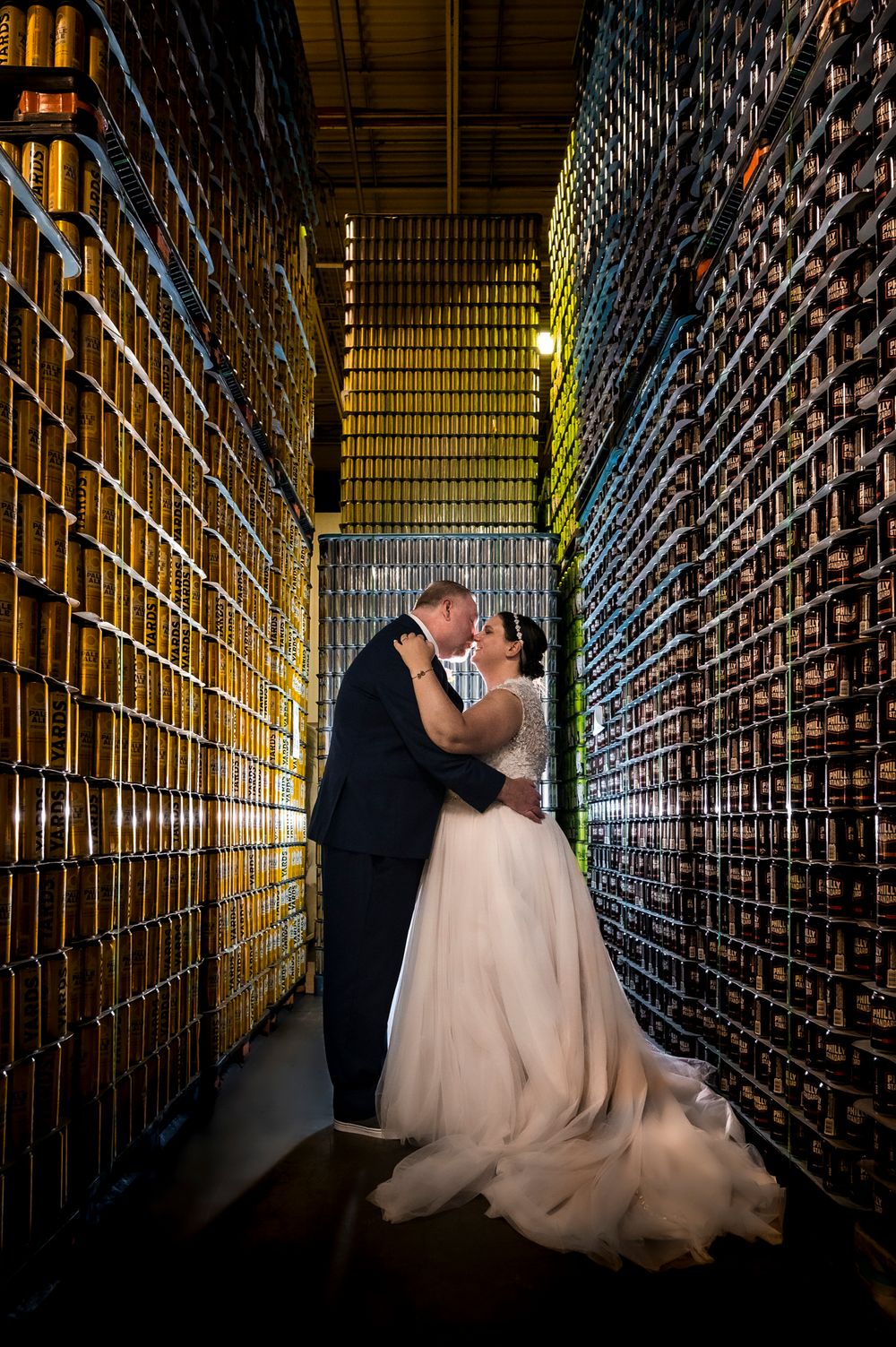 Romantic wedding couple shares intimate moments in a dramatic library setting with towering bookshelves and warm lighting.
