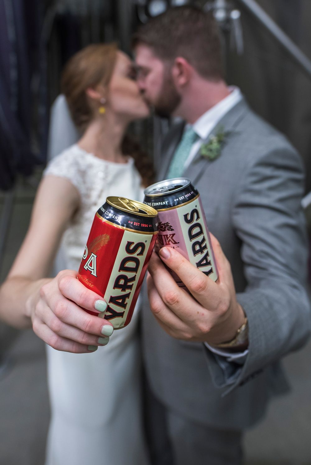 Couple in wedding attire share an intimate moment while holding beer cans in a creative photo series.