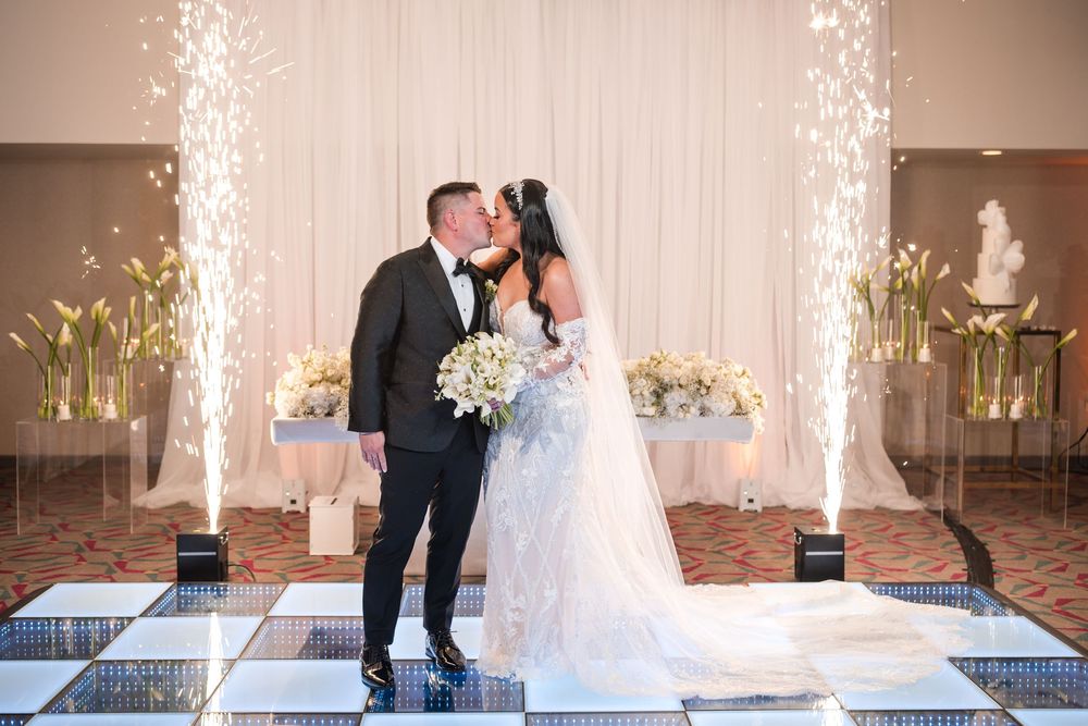 Bride and groom kissing during reception entrance with sparkler effects in Puerto Rico