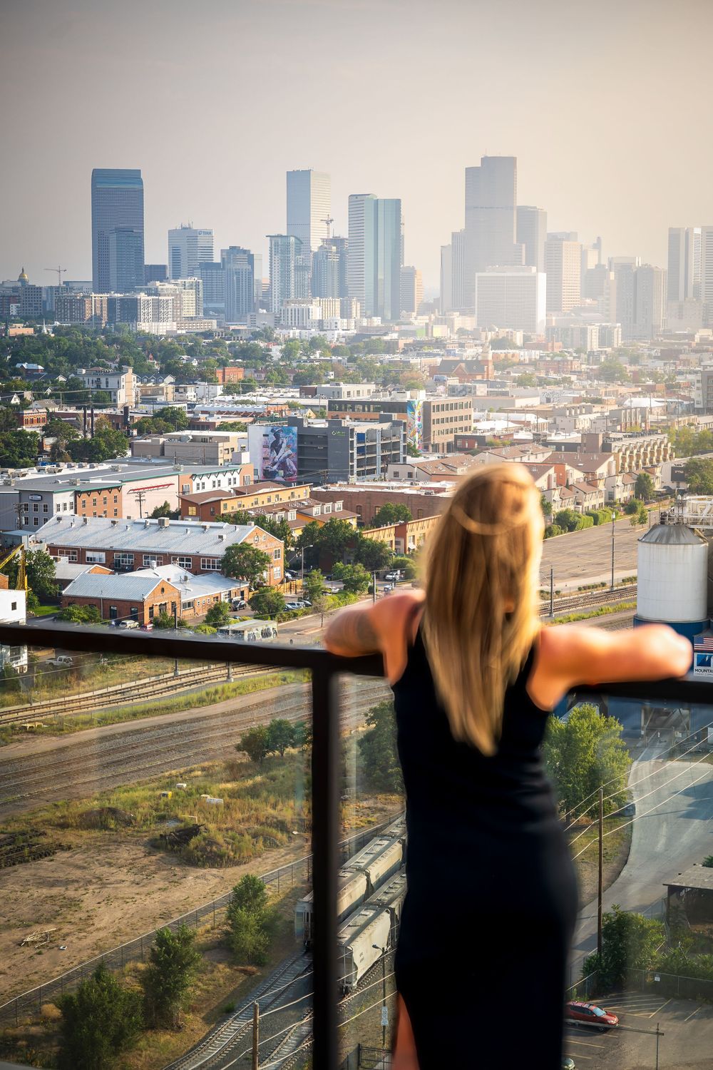 Woman viewing downtown Denver at Rose & Thorn's rooftop by Denver Hospitality, Travel & Tourism photographer Captain Colorado Photography.