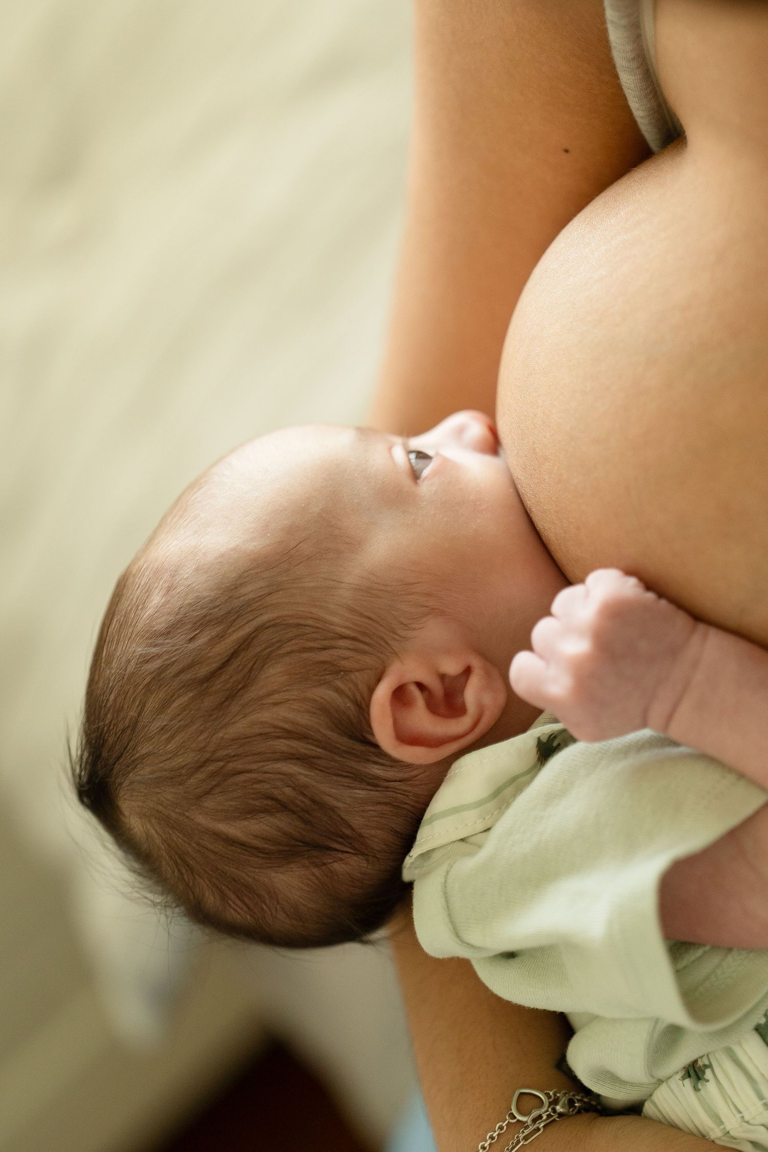 Lifestyle newborn session in Houston home featuring mom nursing her baby boy