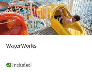 Colorful water slides and tubes twist through an indoor water park with bright natural lighting and glass ceiling.