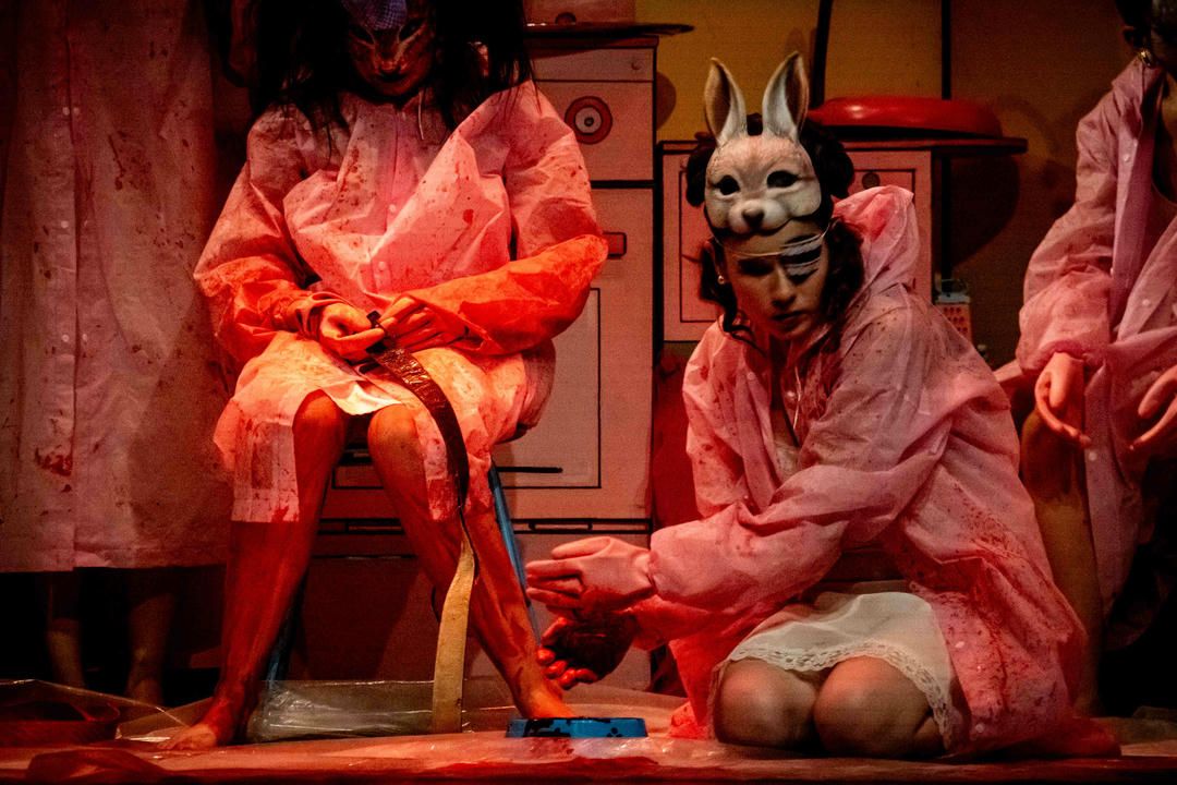 A series of red-tinted theatrical performance photos showing dramatic poses and movements on stage.