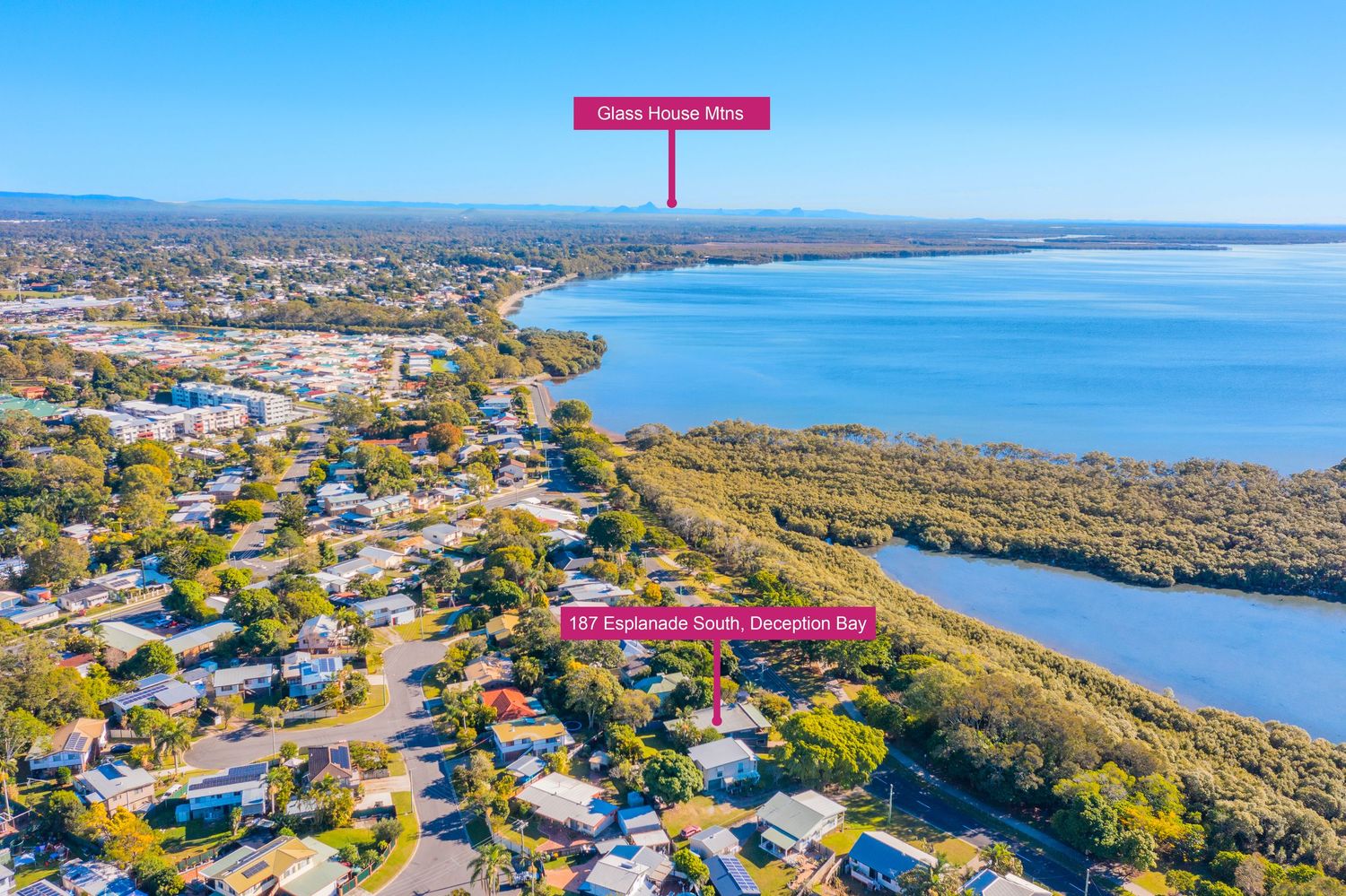 Aerial coastal view of Dunoon Bay suburb with Glass House Mountains visible and waterfront location highlighted.