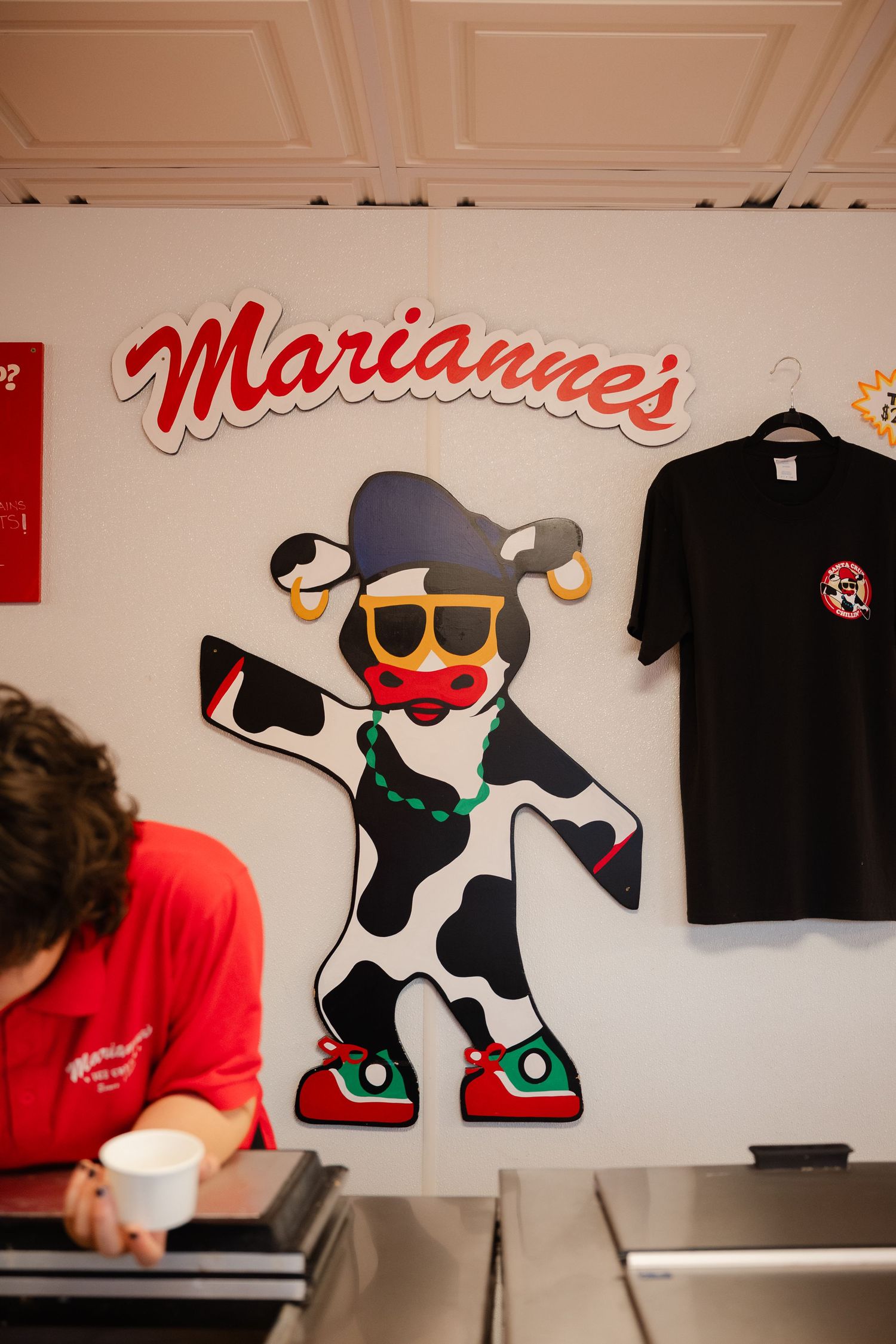 A series of photos showing the creation process of a cartoon character mural on a white wall.