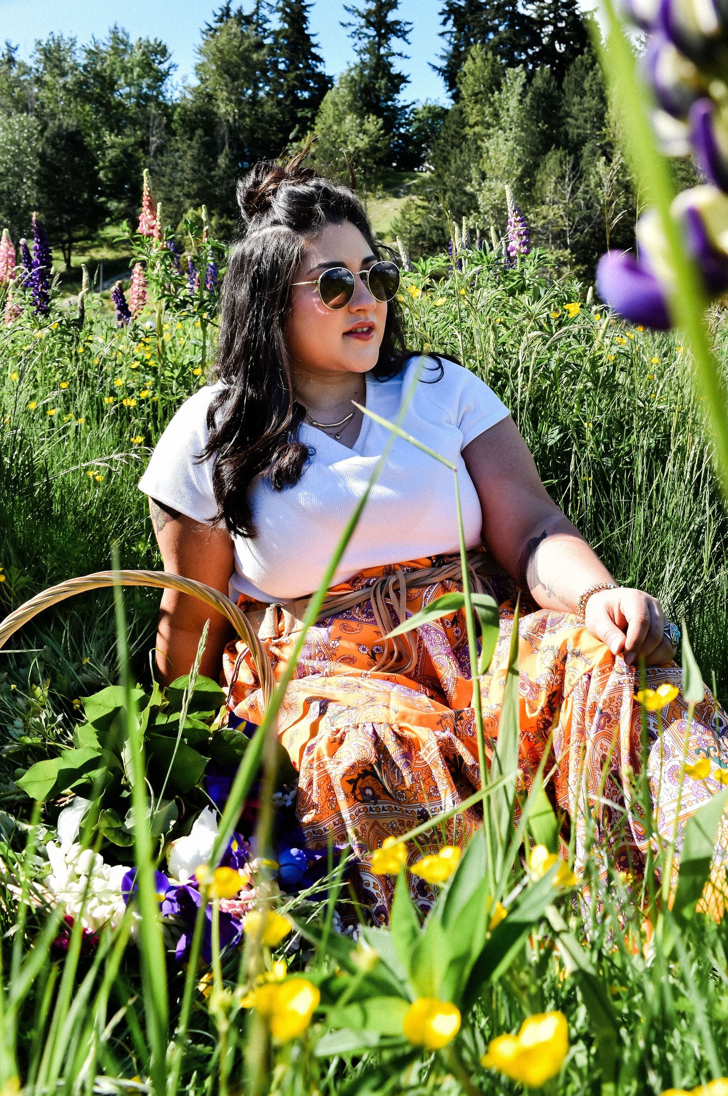 Senior portrait sitting in wildflower field in Van Lierop Park near Puyallup, Washington