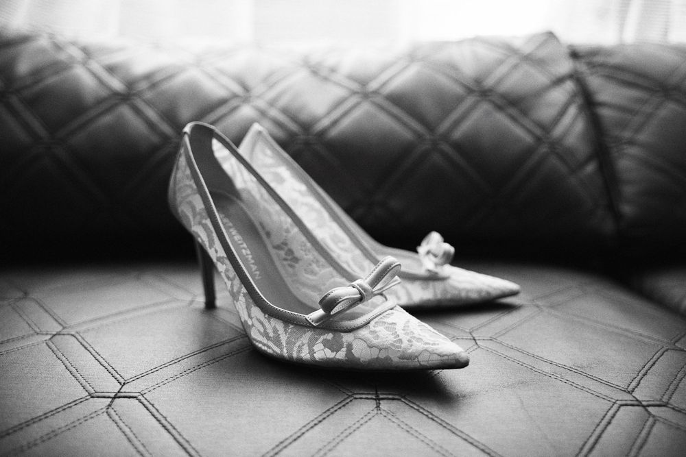 A sequence of black and white images showing a pair of elegant vintage shoes being put on.