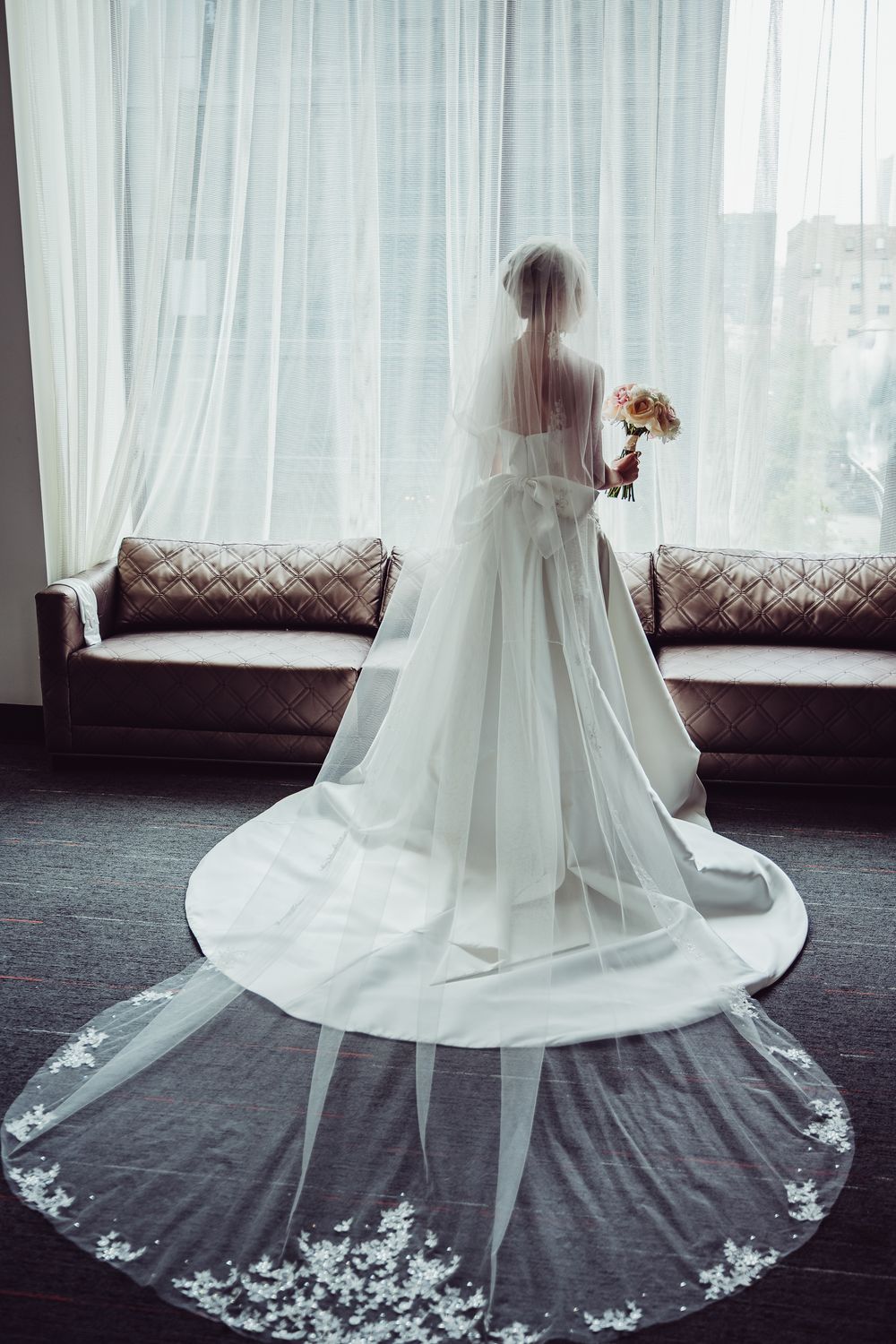 A series of photos showing a flowing white wedding veil with delicate lace trim against a dark carpeted floor.