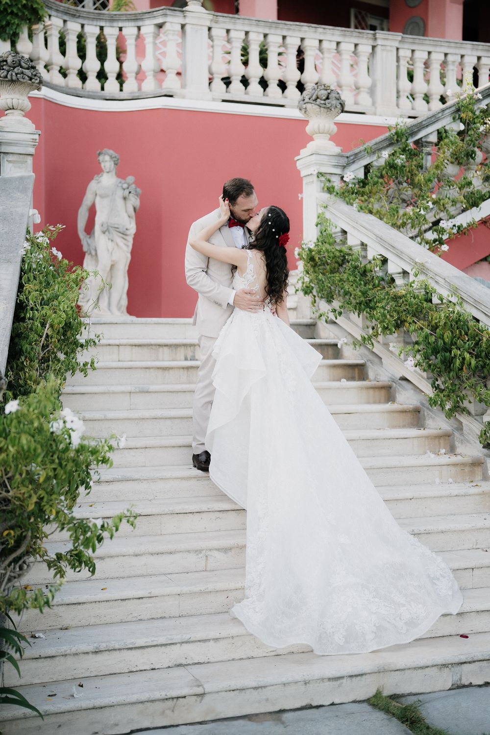Bacio degli sposi sulla scalinata di Villa Casa Rossa a Imperia durante matrimonio con vista mare