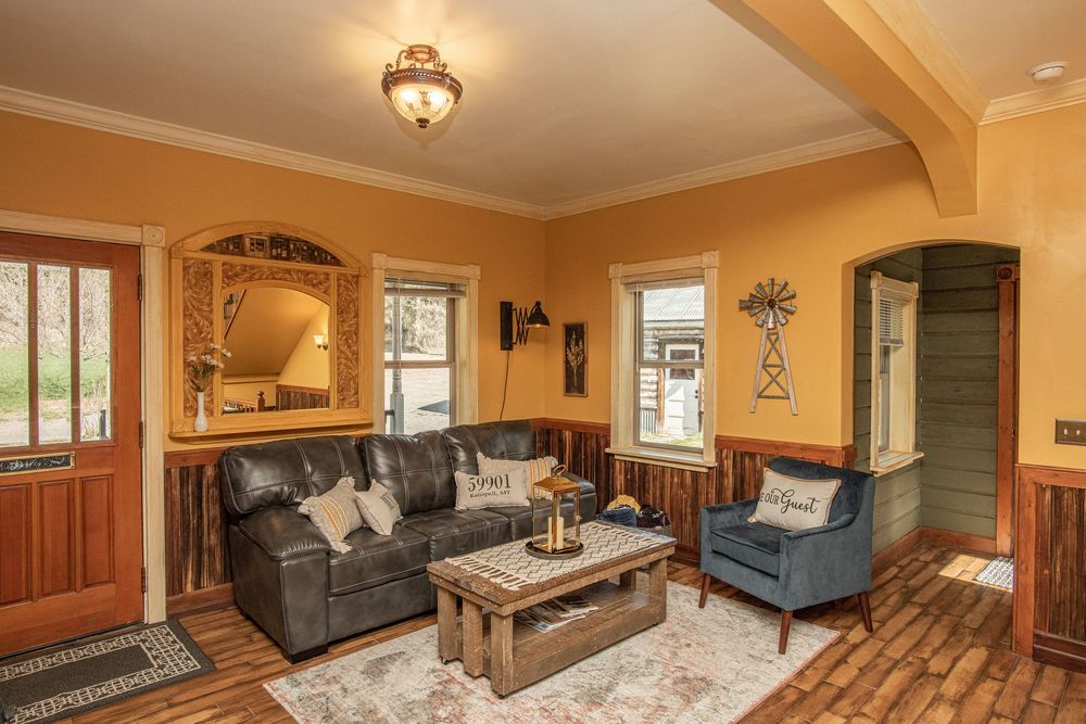 Panoramic view of a cozy living room with warm lighting, hardwood floors, and traditional furnishings.
