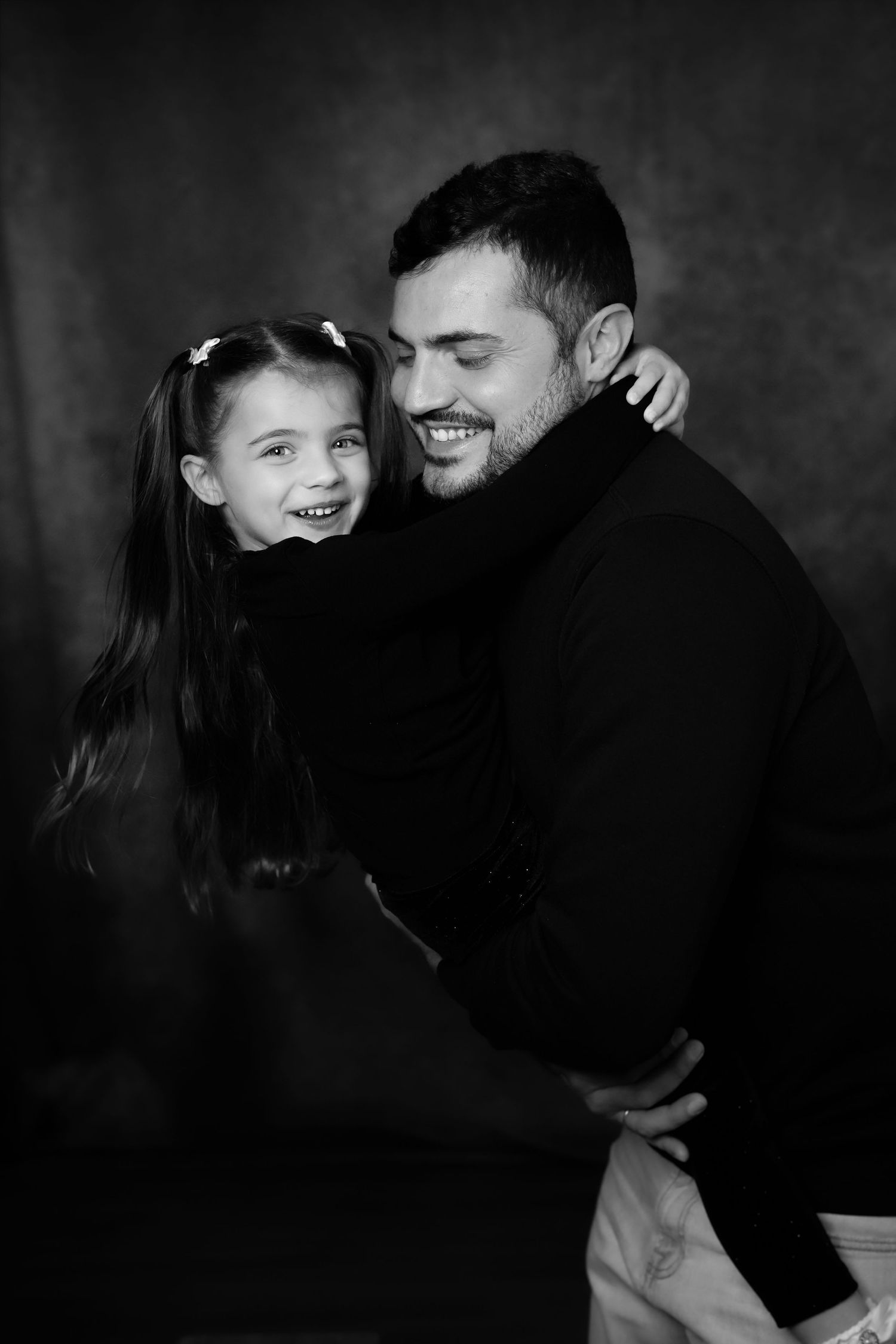 Bambina che abbraccia il papà durante un servizio fotografico di ritratti in studio a Sanremo