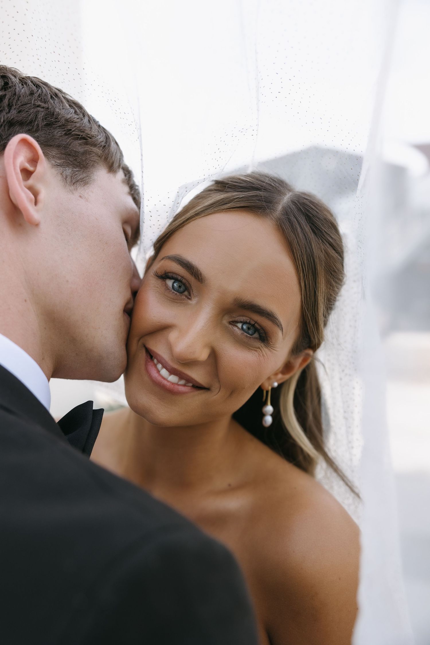 Close-up wedding portrait showing tender moment between newlyweds.