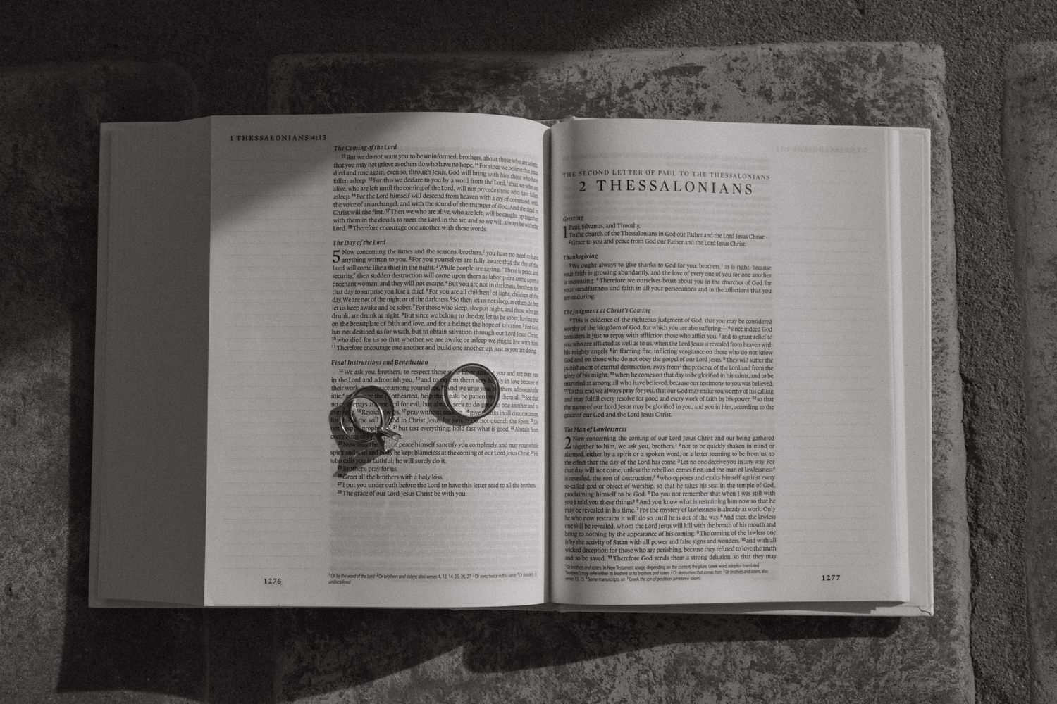 Open book displaying wedding rings on its pages in black and white.