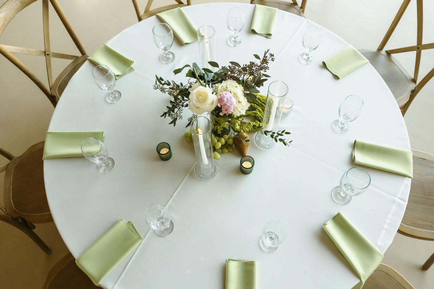 Overhead view of an elegant white wedding table setting with floral centerpiece.