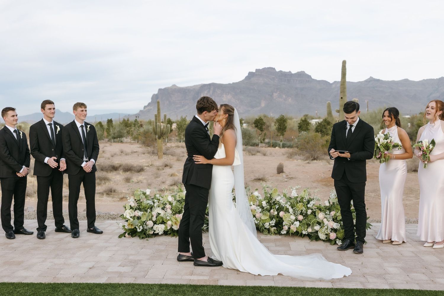 Wedding ceremony with desert mountain backdrop and elegant floral arrangements.