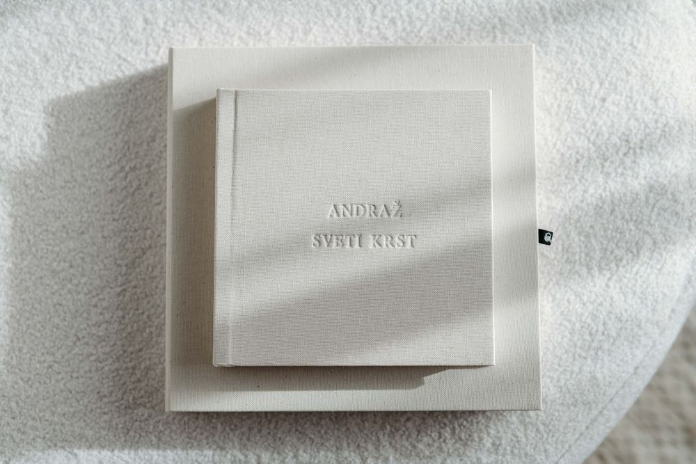 White wedding album cover with embossed text 'SVETI KRST' on textured paper background.