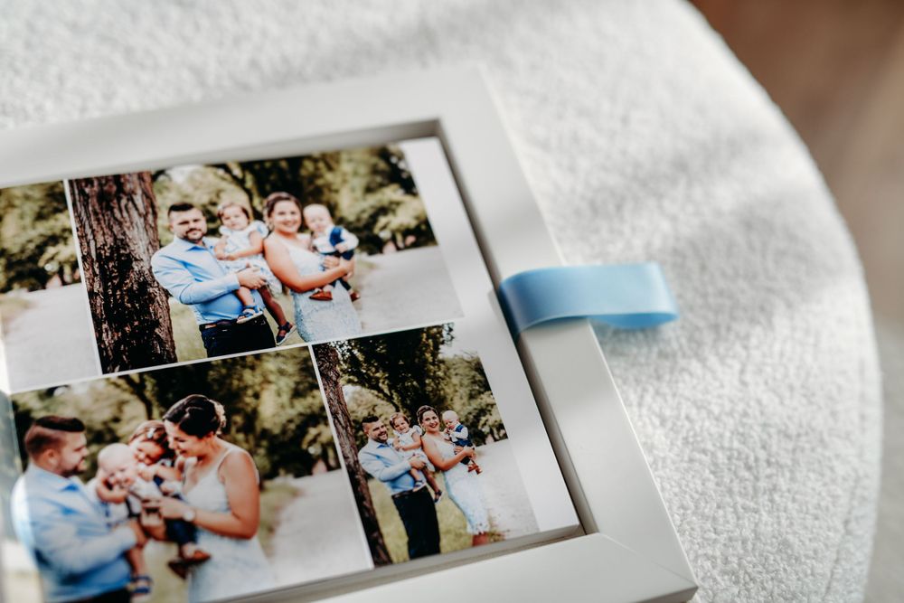 Wedding photos printed on paper held together with blue washi tape against white textured background.