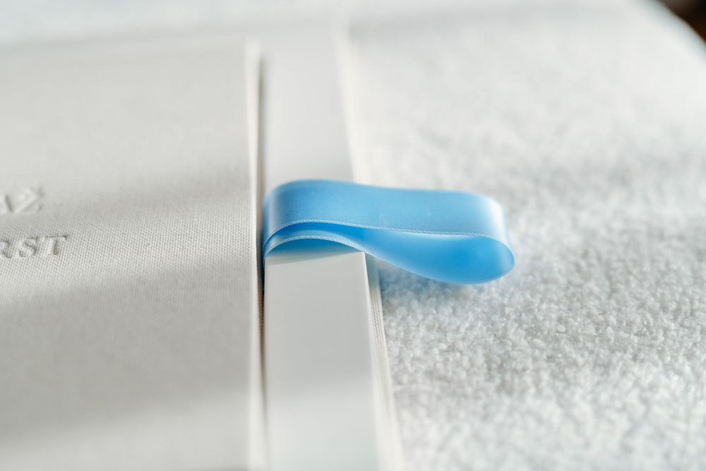 Close-up of a light blue ribbon bookmark against white paper.