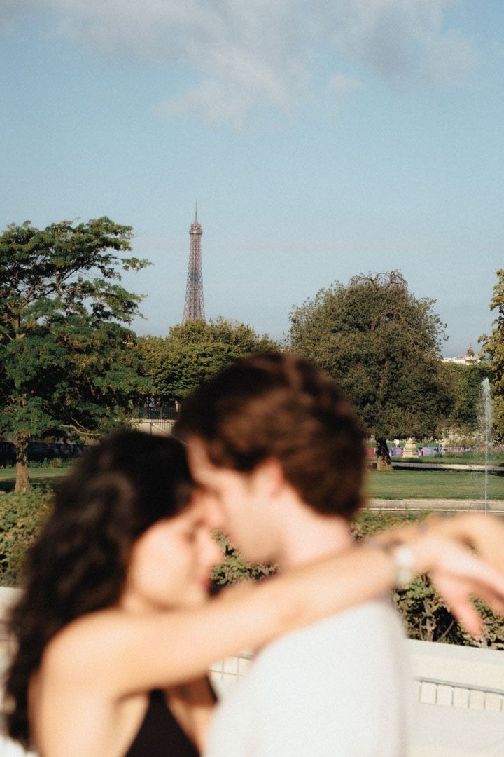 Silhouettes of people posing with the distant Eiffel Tower visible in the background.