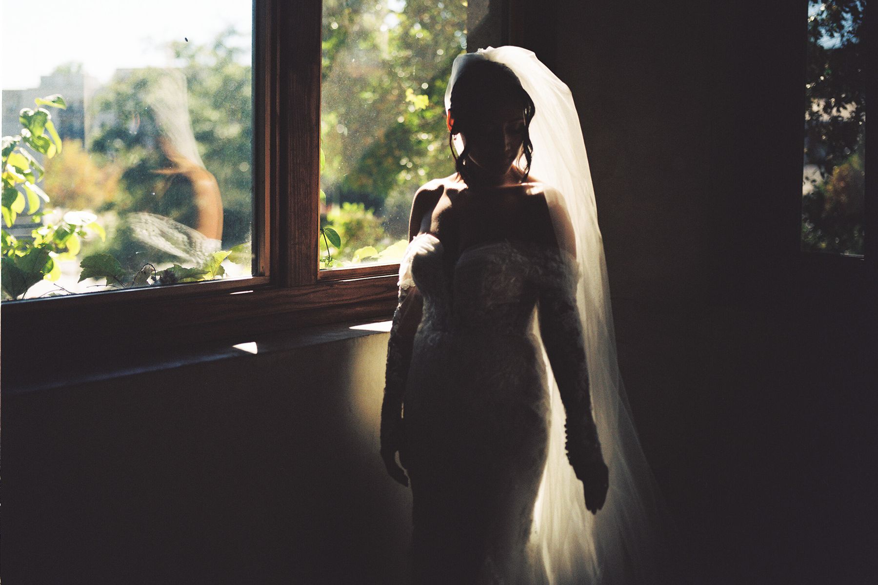 Silhouettes create dramatic lighting effects during wedding preparation.