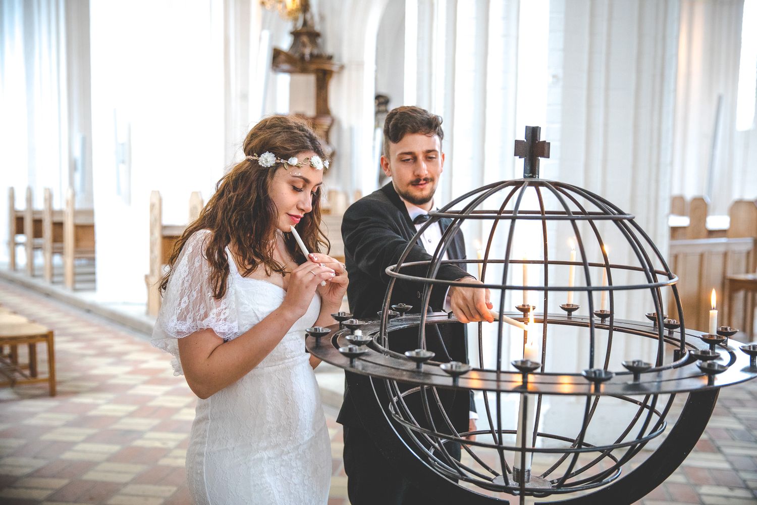 A couple sharing a playful moment while interacting with a large decorative metal globe sculpture.
