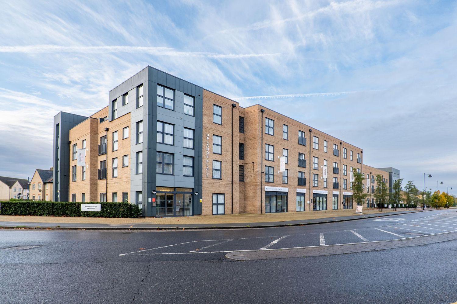 Modern apartment complex with mixed brick and grey facade on a corner street location.