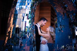 A romantic moment captured under a glittering blue mosaic archway at night with dramatic lighting captured by wedding photographer near me.