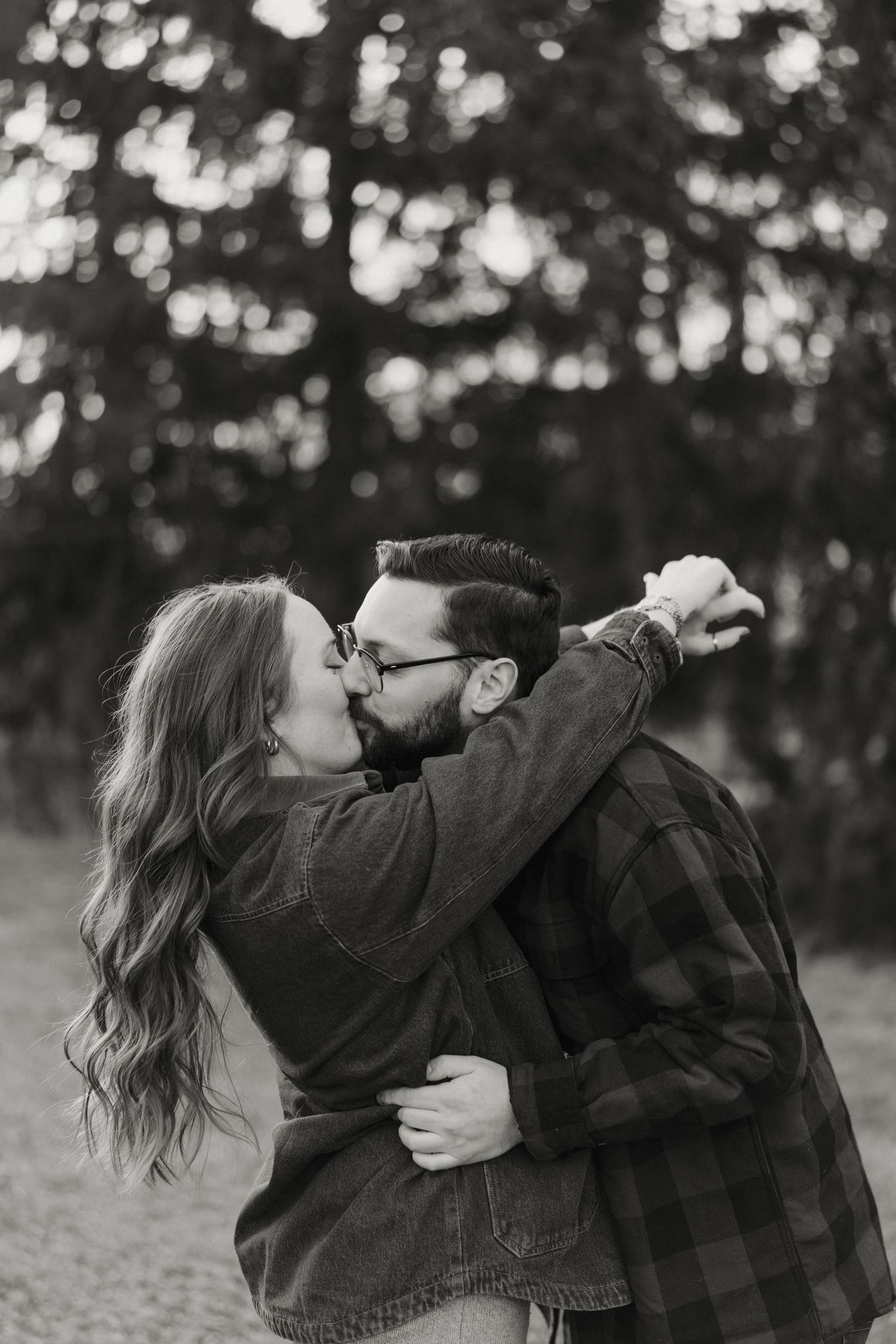 An intimate maternity photo taken in a minimalist dining room with natural lighting streaming through the windows.