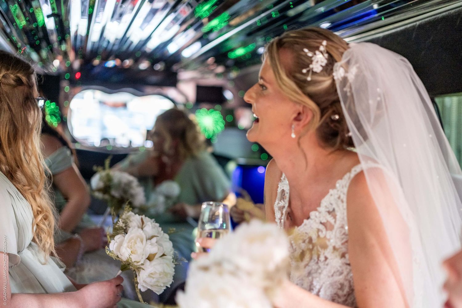 Candid celebration moment inside a decorated limousine with white floral bouquet and festive lighting.