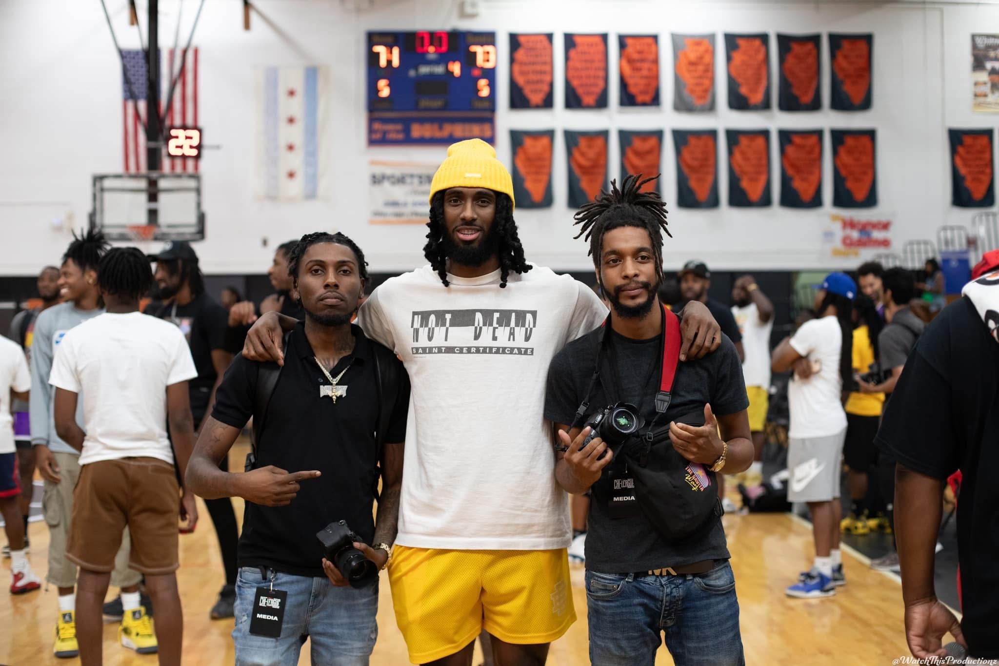 Casual gathering of attendees in a gymnasium with basketball championship banners.
