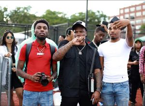 Group of people outdoors at event with cameras and casual attire.