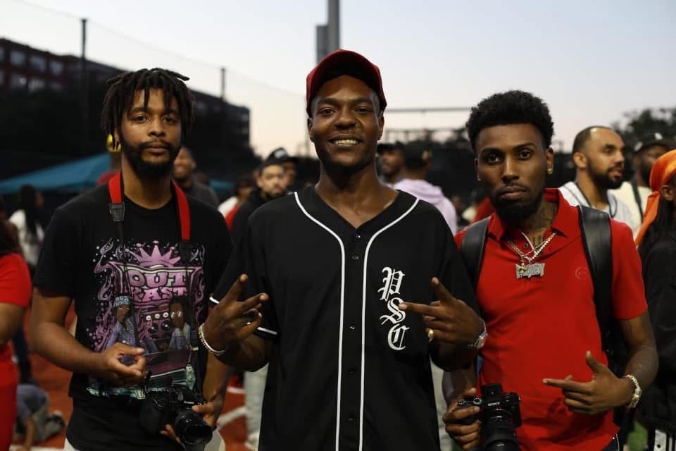 Outdoor event attendees in casual streetwear posing together.