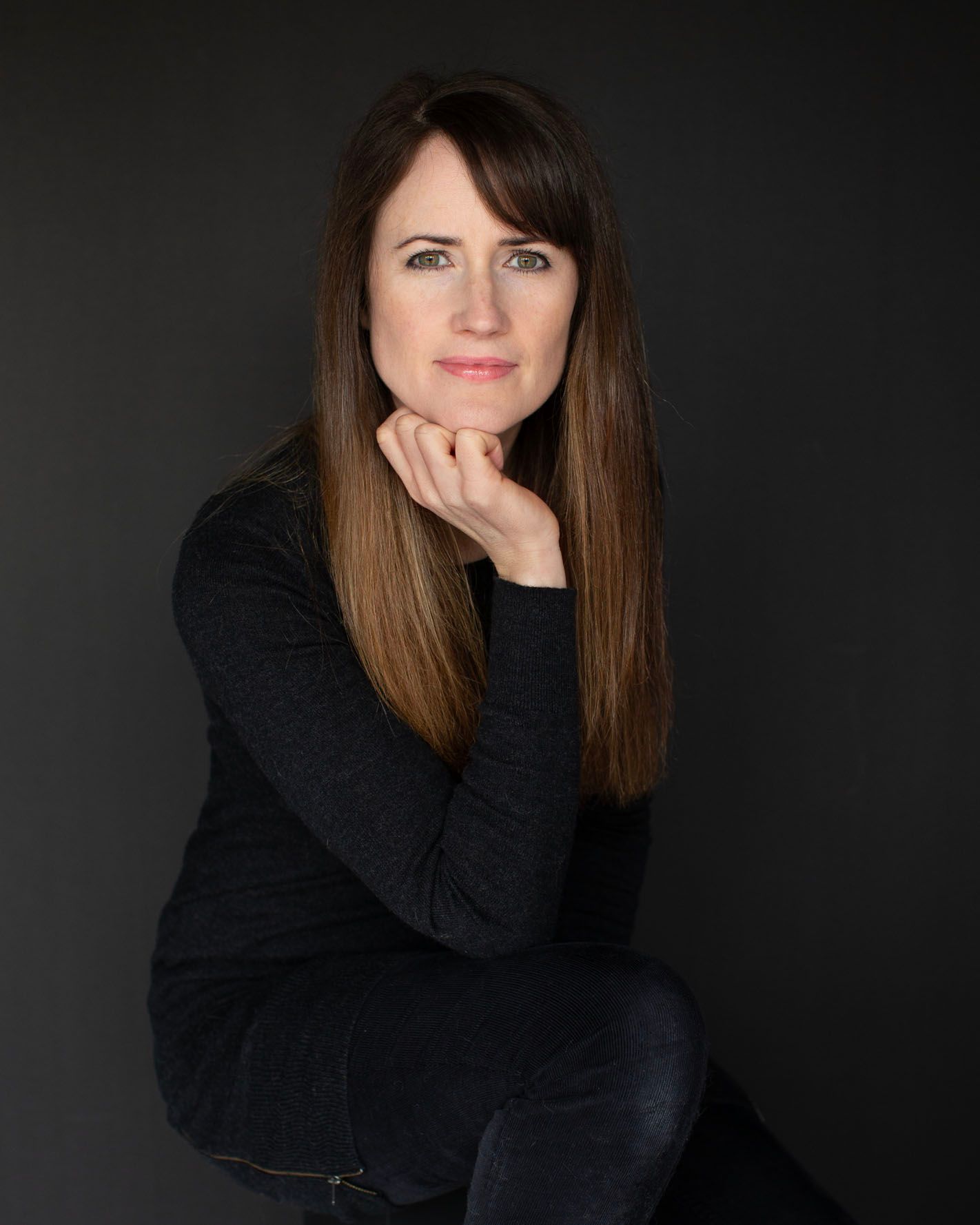 Photo of photographer Abigail Stewart wearing black on a black background