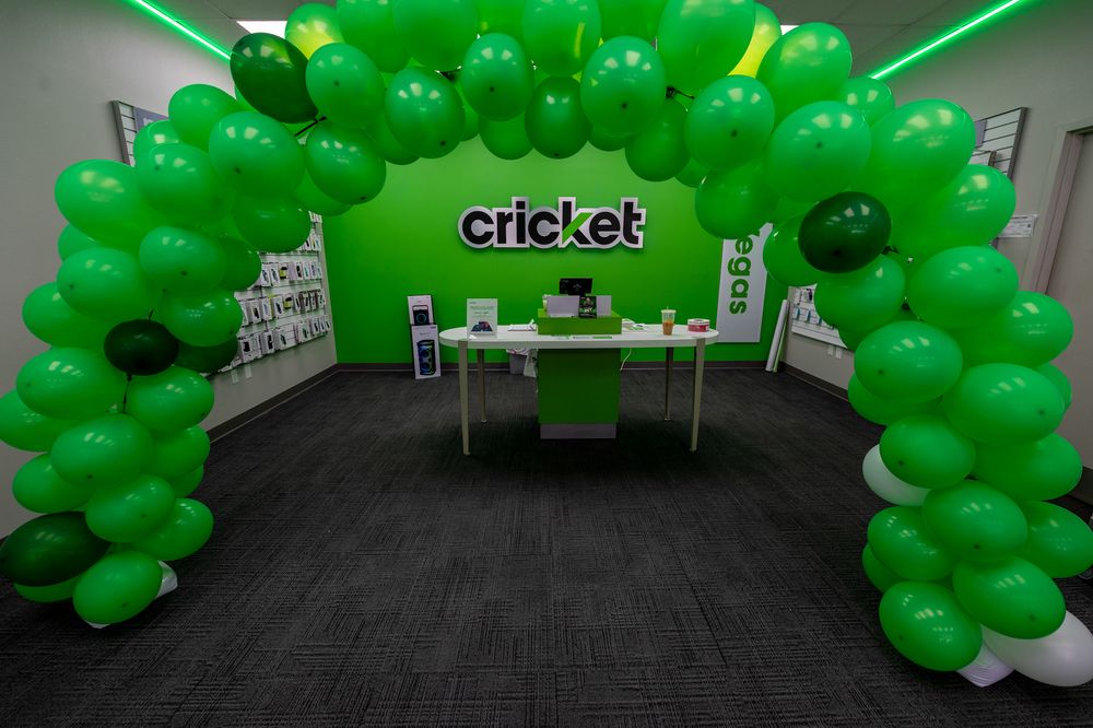 Green balloon arch decorations in a retail space with Cricket wireless branding.