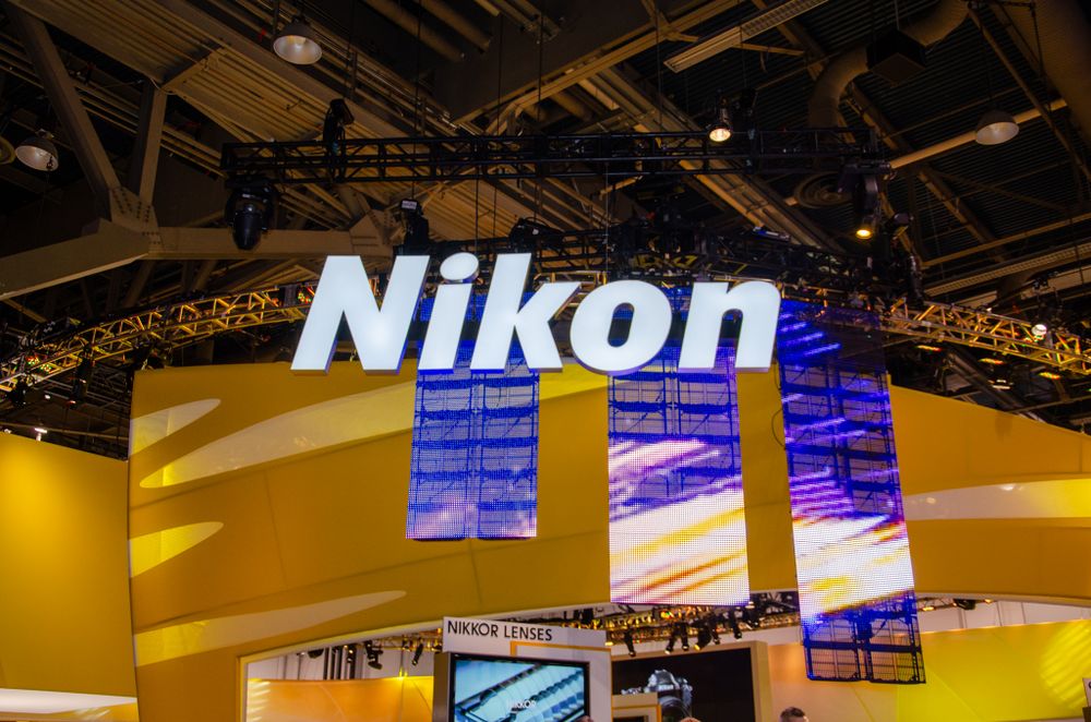 Exhibition hall interior with Nikon branding and suspended lighting fixtures.