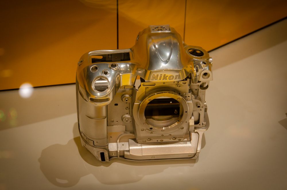 Golden-tinted display of professional camera equipment under spotlight.